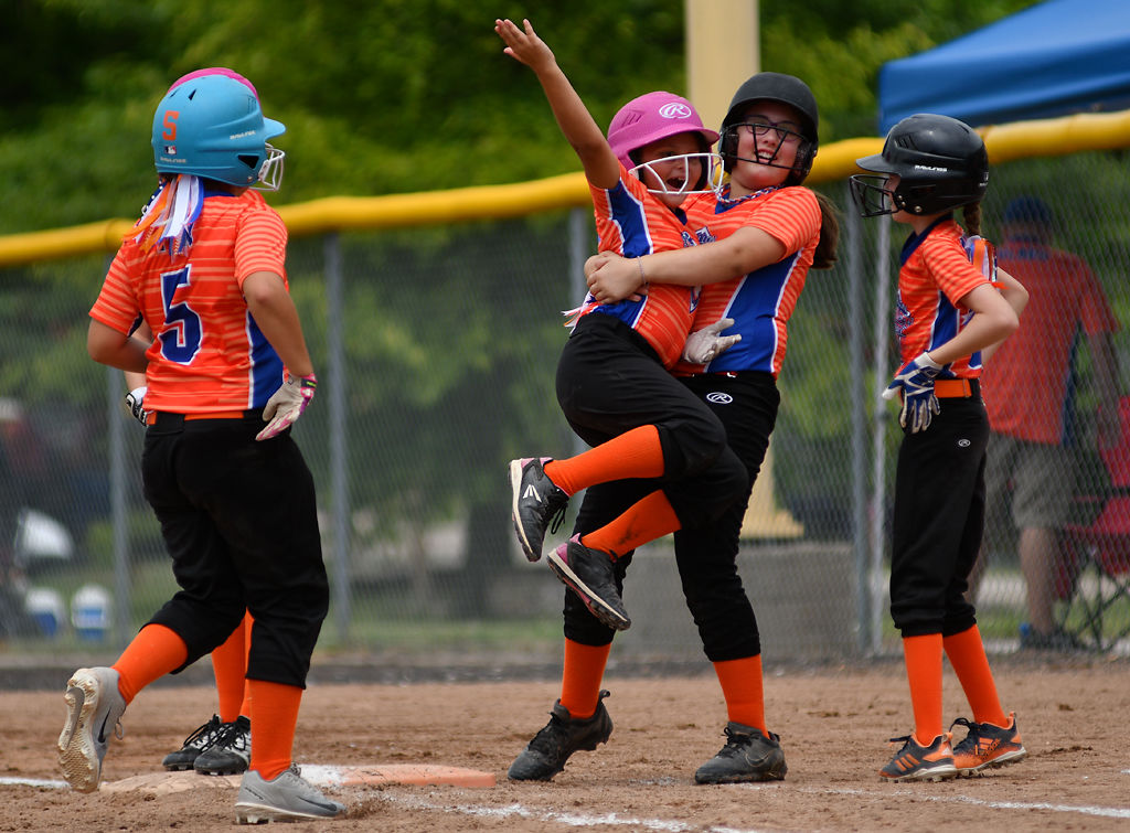 Alyssa James, 10, carries her teammate, Sydney Bonzo, 9, as the team celebrates